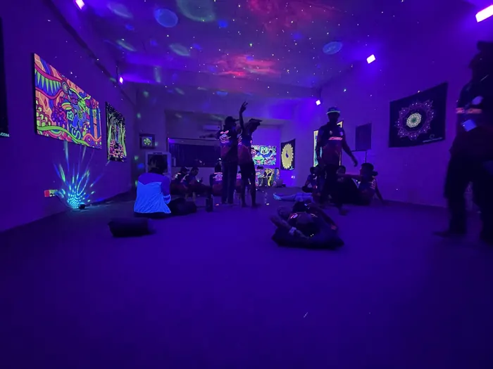 Visitors inside the gallery under UV light