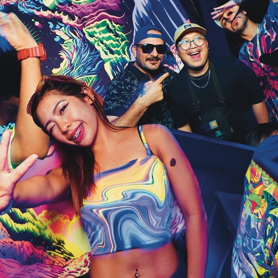 Woman in a swirl-print top smiling and throwing a peace sign