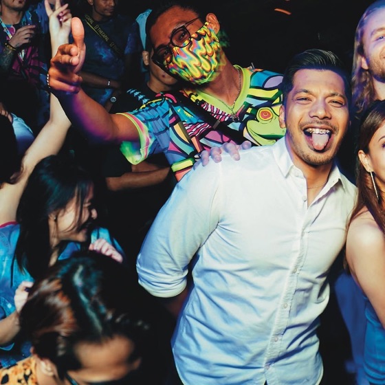 Man in a white shirt sticking his tongue out in the crowd