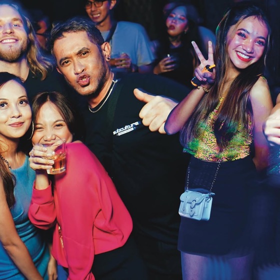 Group of friends posing together with thumbs up and peace signs